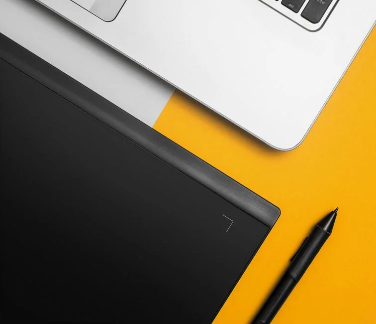 Une femme savoure un café tout en naviguant sur le web sur un ordinateur portable, installée à un bureau dans un espace de travail à domicile.