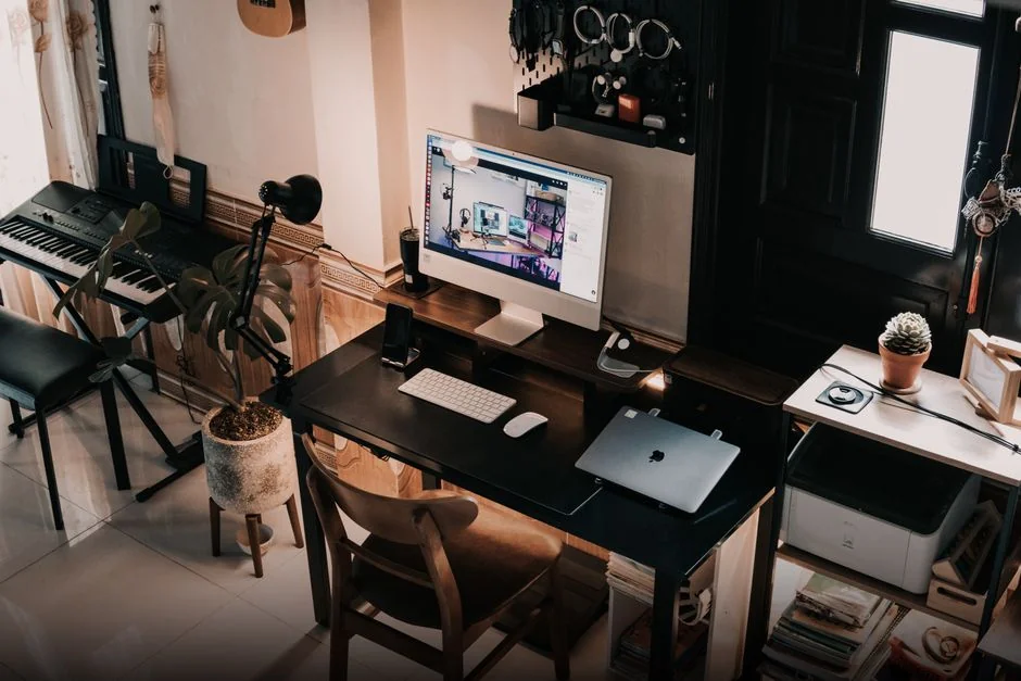 Woman in floral dress shopping online with a laptop and credit card indoors.